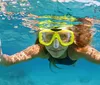 A person is giving two thumbs up while snorkeling underwater wearing a yellow mask
