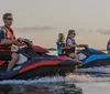 Three people an adult and two children are having fun riding a blue jet ski on a sunny day