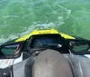 A person is riding a yellow and black jet ski on the water at high speed