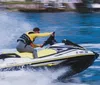 A person is riding a yellow and black jet ski on the water at high speed