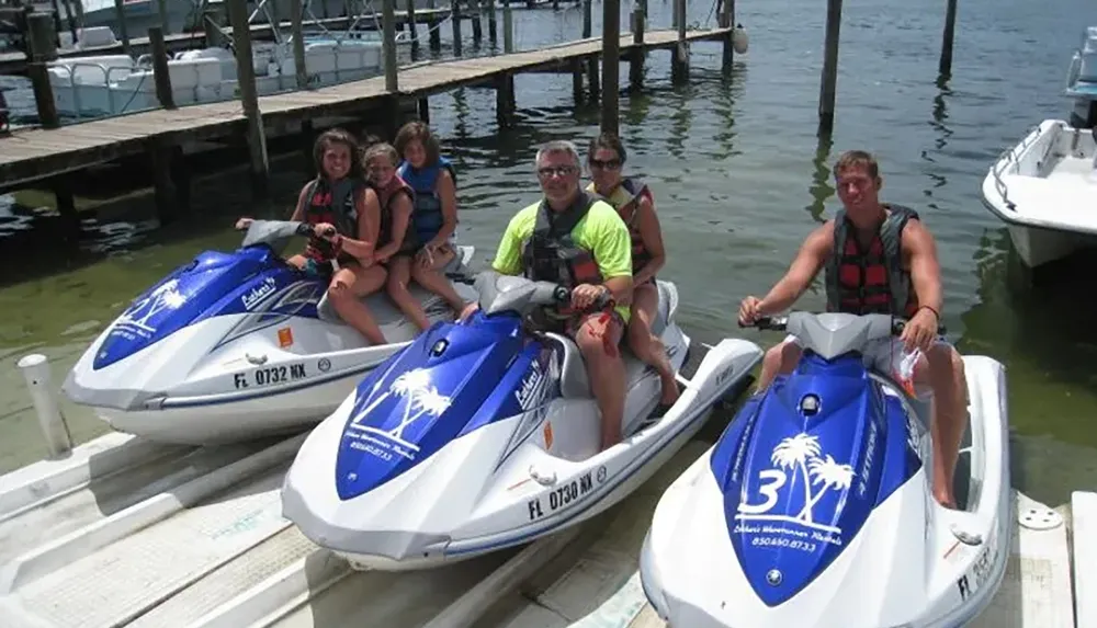 The image shows a group of people on three separate jet skis at a dock ready for some water activities