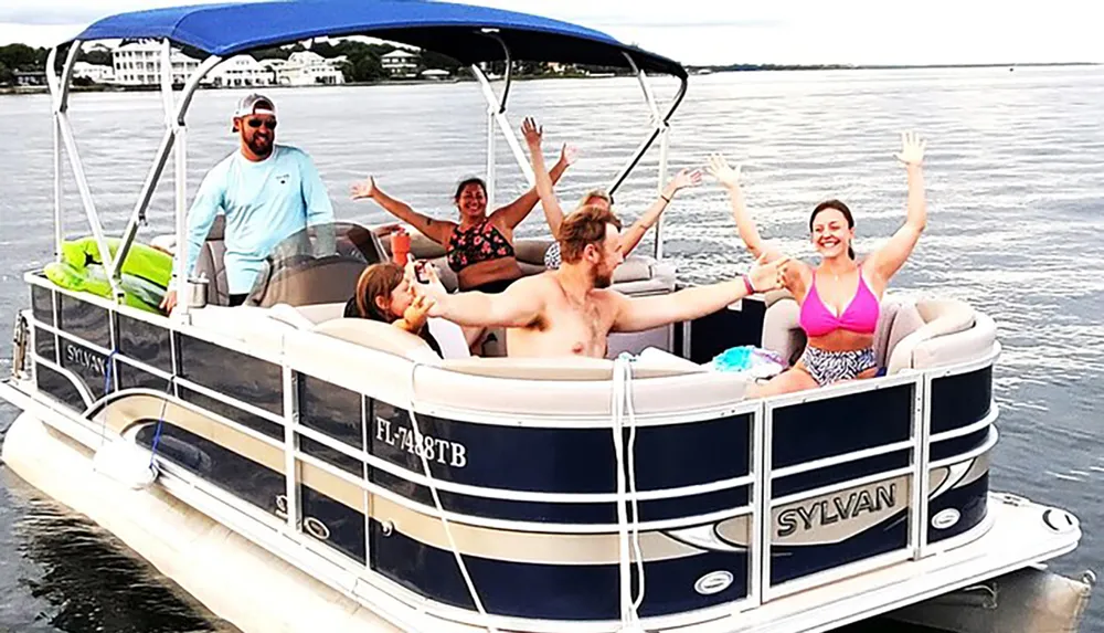 A group of people are having a joyful time on a pontoon boat with smiles and raised hands signaling excitement or celebration