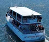 A tour boat is filled with passengers as they enjoy a vivid sunset over the water