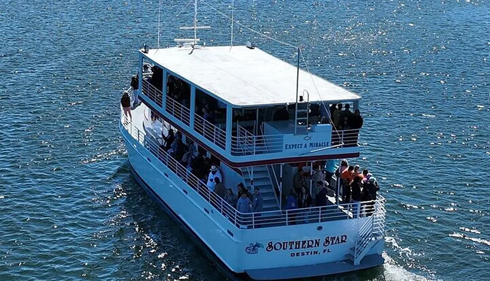 The image shows a two-deck tour boat named SOUTHERN STAR Destin FL filled with passengers enjoying a sunny day on the water