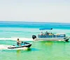 A group of people enjoys a sunny day on a pontoon boat on calm waters with other boats in the background