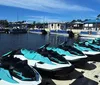 A group of people enjoys a sunny day on a pontoon boat on calm waters with other boats in the background