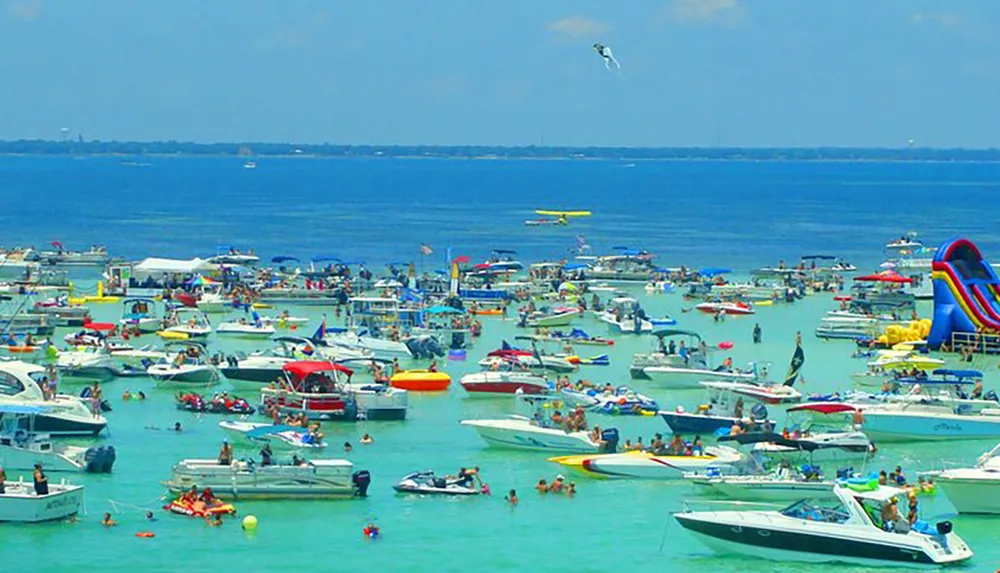 A bustling aquatic gathering with numerous boats and recreational activities taking place in a vibrant blue water setting