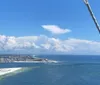 Two people are enjoying themselves while parasailing above a clear blue ocean