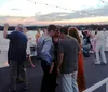 The image shows an evening scene with the Solaris yacht docked in a marina with a close-up inset of a dish that appears to be shrimp and grits all set against a backdrop of a coastal resort town under a moonlit sky