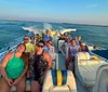 A group of people enjoying a boat ride near a bridge during sunset