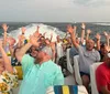 A group of people enjoying a boat ride near a bridge during sunset