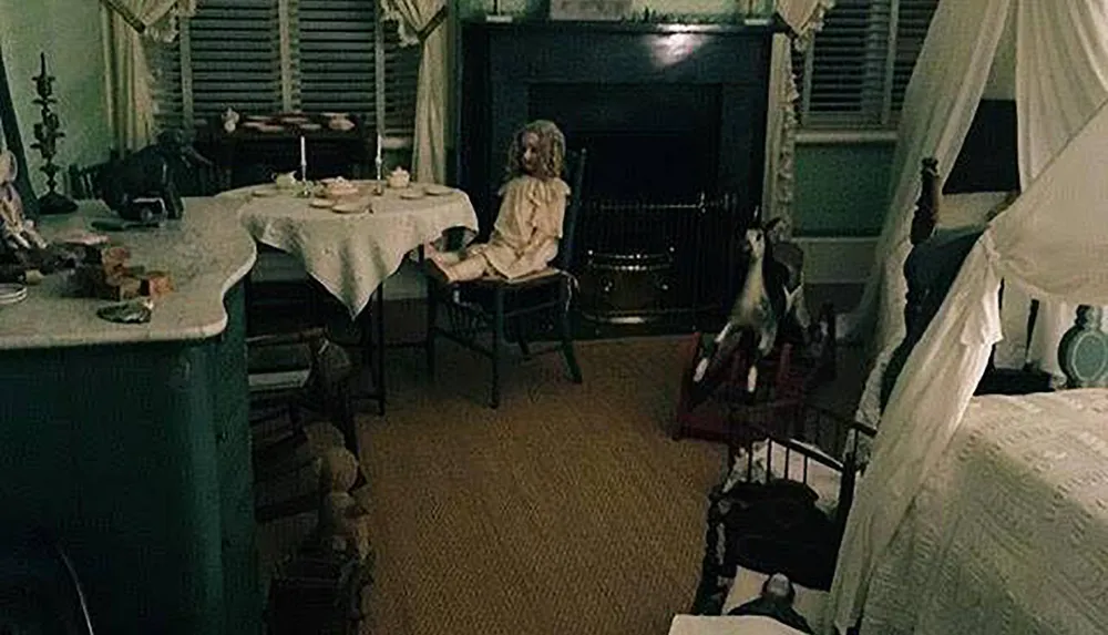 The image features a dimly lit vintage room with antique furnishings where a creepy doll is seated on a chair by a fireplace creating an eerie atmosphere