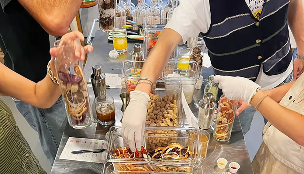 People are participating in a hands-on cocktail or beverage mixing workshop with various ingredients laid out on a table