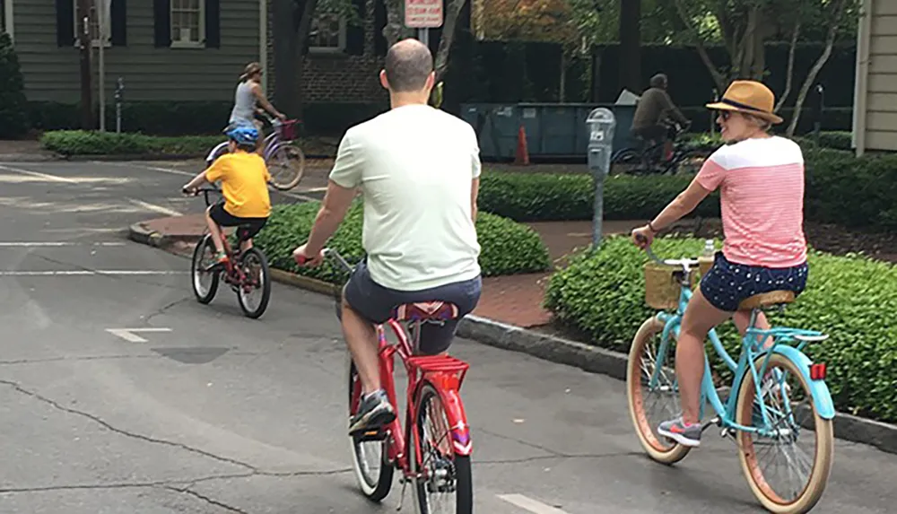 A family is enjoying a leisurely bike ride together along a city street