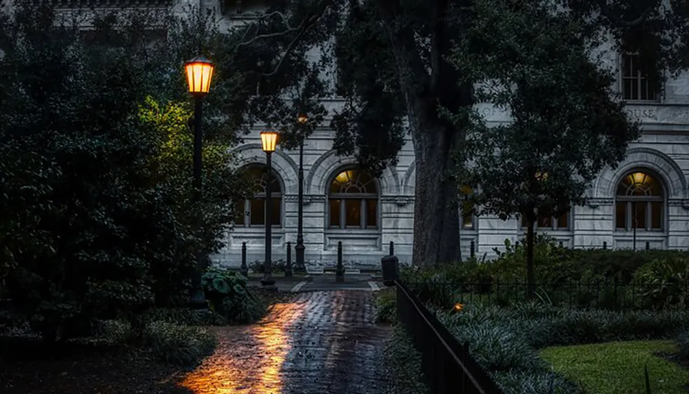 The image depicts a tranquil evening scene of a pathway leading to a stately building illuminated by the warm glow of street lamps amidst verdant foliage