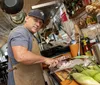 A person in an apron and baseball cap is preparing food in a well-equipped homey kitchen setting