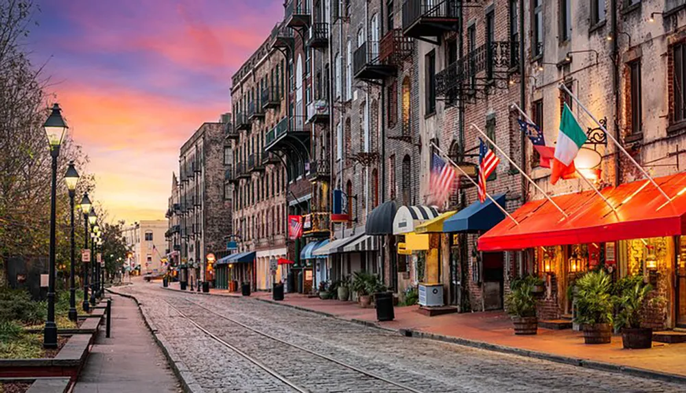 A vibrant street lined with colorful awnings and historic buildings under a sunset sky featuring a cobblestone road and tram tracks