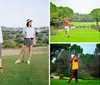 Two people are standing on a golf course with the person in the foreground holding a golf club looking towards the camera and the person in the background posing with a club over her shoulder