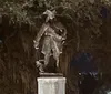 The image shows a peaceful cemetery adorned with statues and Spanish moss-hung trees conveying a serene final resting place