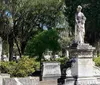 The image shows a peaceful cemetery adorned with statues and Spanish moss-hung trees conveying a serene final resting place