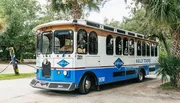 A trolley-style tour bus with the branding of 