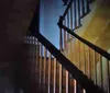 The image is a blurry and low-resolution photo of an indistinct figure standing on a staircase giving it an eerie or ghostly appearance