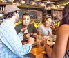 A group of people appear to be enjoying each others company at a bar or restaurant with drinks and food on the table