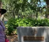 A person is standing next to a memorial plaque commemorating a 1733 burial plot allotted by James Edward Oglethorpe to the Savannah Jewish Community