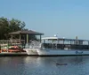 A group of people is enjoying a ride on a riverboat named Ohana that is docked along a city waterfront