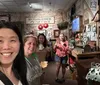 Four people pose for a selfie in a room filled with historical exhibits and memorabilia related to moonshine and car racing
