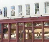 This image shows the facade of The Olde Pink House an elegant pink-colored historical building housing a restaurant and tavern flying both the American and British flags at dusk