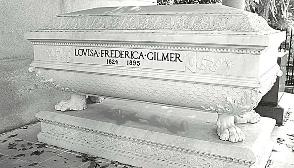 The image shows an elaborately designed sarcophagus on pedestal feet with the carved inscription LOVISAFREDERICAGILMER 1824 1895