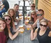 A group of people is smiling at the camera while holding up drinks at an outdoor table marked with the number 11