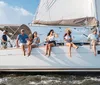 A group of people are enjoying a sunny day sailing on a yacht