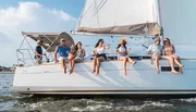 A group of people are enjoying a sunny day sailing on a yacht.