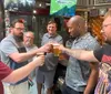 A group of men are toasting with glasses of beer in a sociable atmosphere possibly at a bar or pub