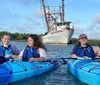 A group of smiling people are enjoying kayaking together on a sunny day in a calm waterway with grassy banks