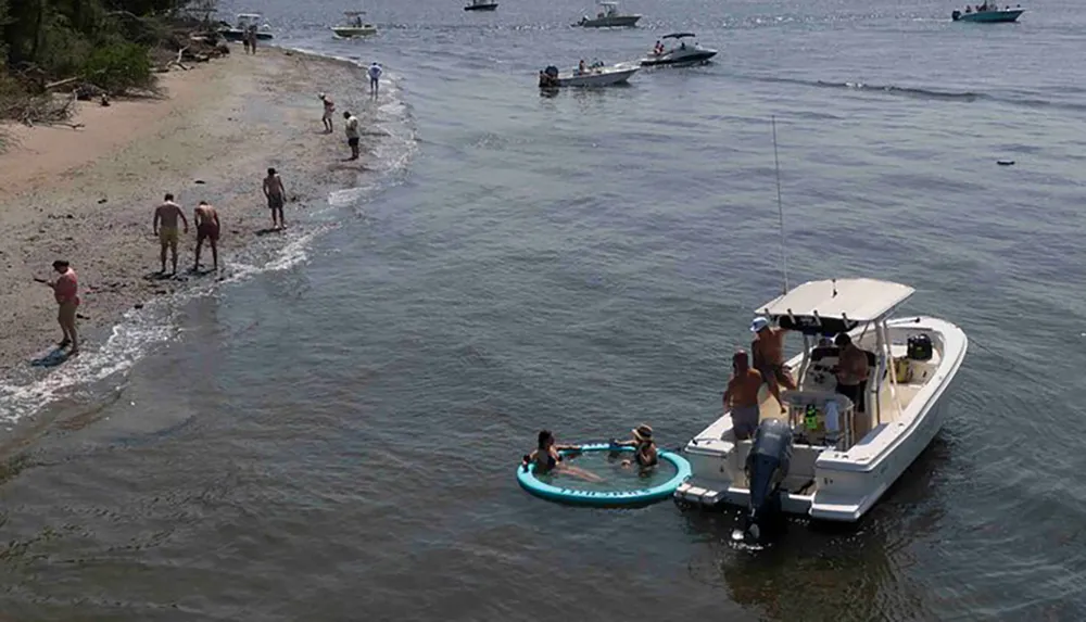 The image shows a sunny day with individuals relaxing on a boat and enjoying water activities while others are fishing or walking along the shoreline