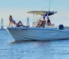 A group of people is enjoying a sunny day on a motorboat on calm waters with a bridge in the distant background