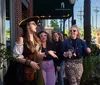 A group of people is attentively listening to an individual dressed in period costume during what appears to be a nighttime ghost tour outside a historical building