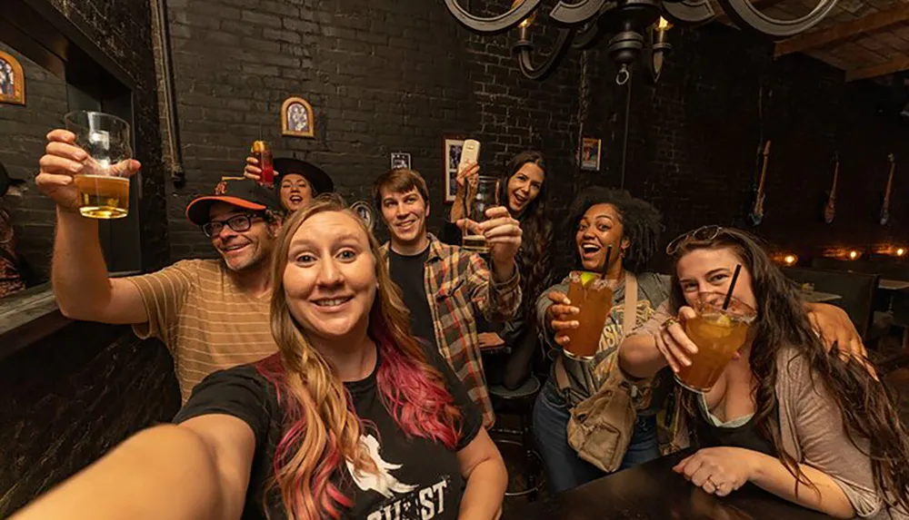 A group of joyful people is taking a selfie while raising their glasses for a toast in a cozy bar setting