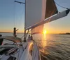 A group of smiling people are enjoying a meal together on a sailboat