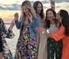 A group of smiling people are enjoying a meal together on a sailboat