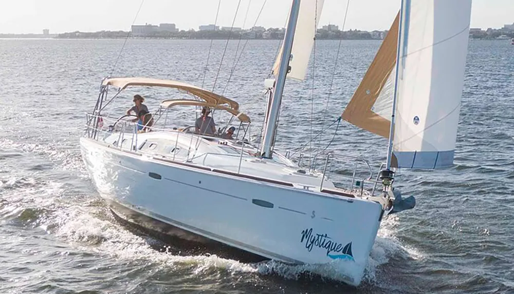 A sailboat with several passengers is navigating through the water on a sunny day