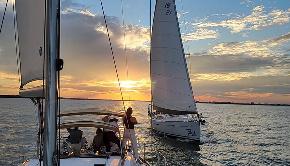 A group of people relaxes on a sailboat enjoying the sunset over the water