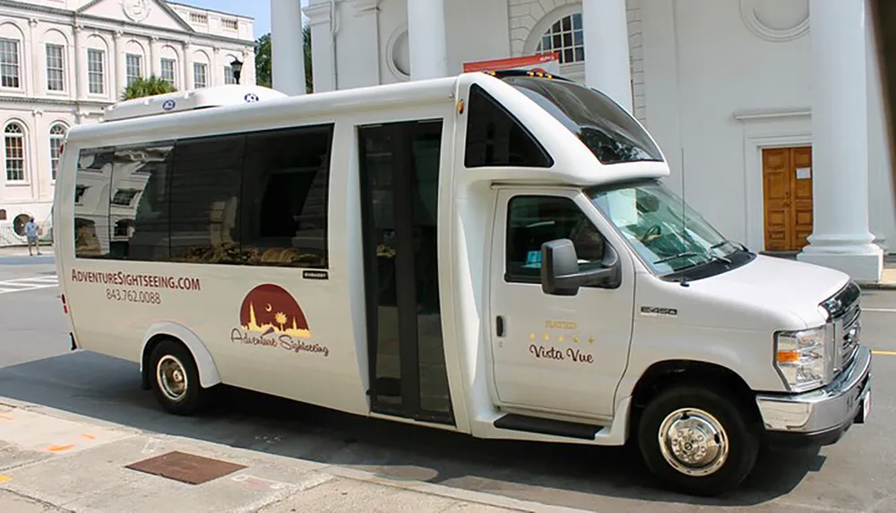 The image shows a white tourist sightseeing shuttle bus parked on a street beside a building with white columns