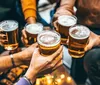 A group of people is toasting with glasses of beer in a social gathering