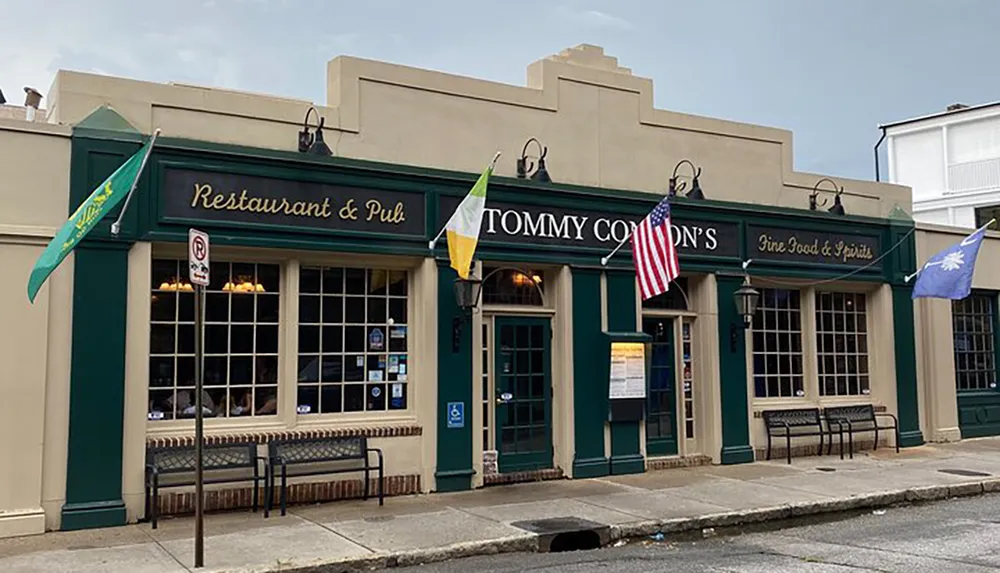 The image shows Tommy Condons Restaurant  Pub adorned with an Irish flag an American flag and another unidentifiable flag indicating a place that likely offers a combination of Irish and American hospitality