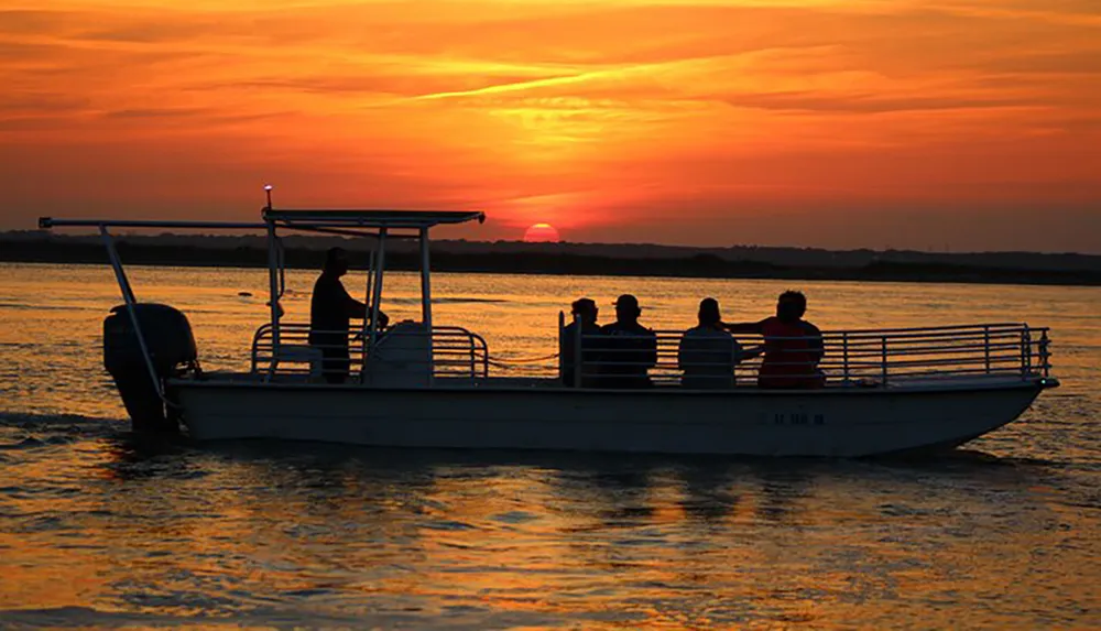 A group of people on a boat enjoys a scenic sunset over the water