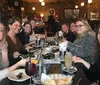 A group of people is enjoying a meal together at a restaurant with smiles and various dishes on the table